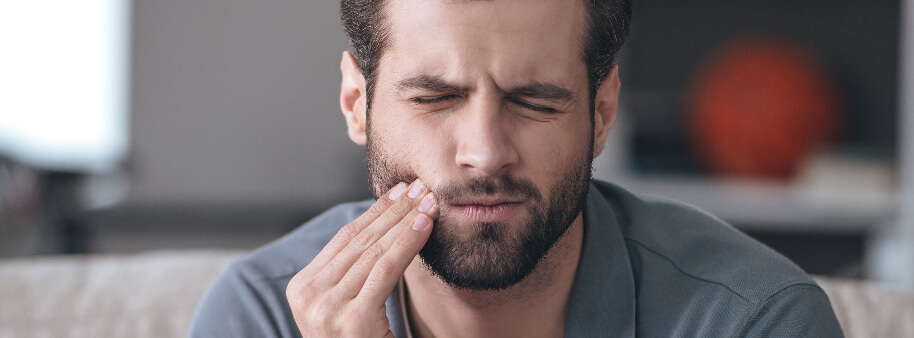 man holding mouth pain tooth sensitivity