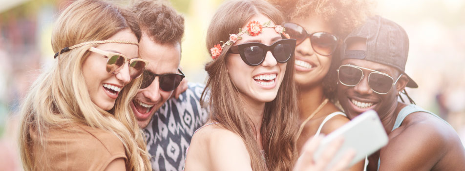 young adults smiling for selfie at music festival