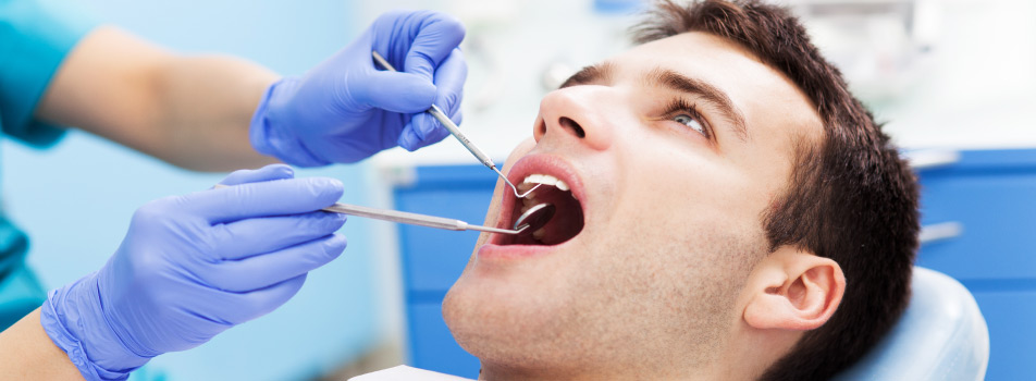 Brunette man gets his teeth professionally cleaned by a dental hygienist at Southwest Smiles Family Dentistry