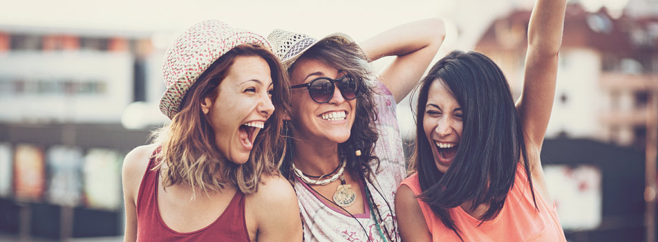 3 female friends smile brightly with tooth-colored fillings on a summer day outside