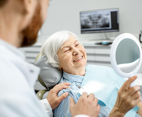 smiling senior woman sitting in a dental chair