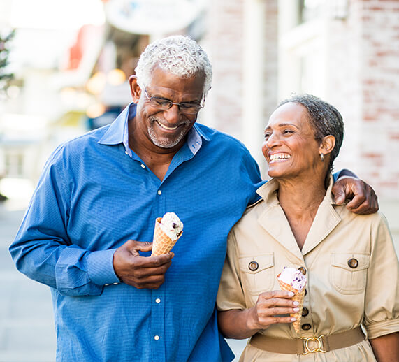 man and woman walking with ice cream