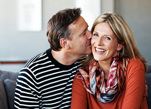 man kissing woman on cheek