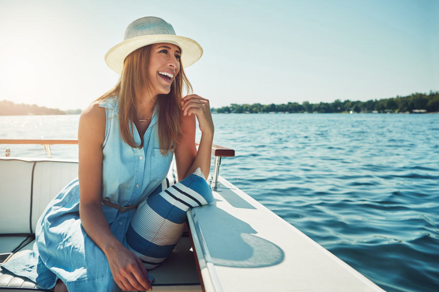 Happy woman with a dental crown smiles while boating on the lake in Austin, TX