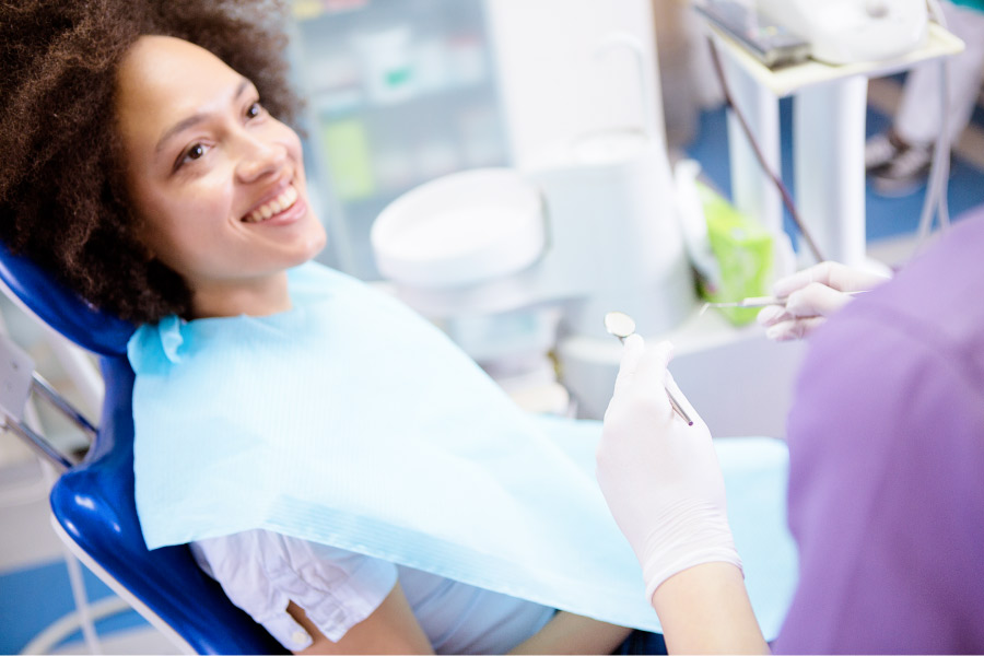 Brunette woman smiles before the dentist checks her mouth for decay and cavities