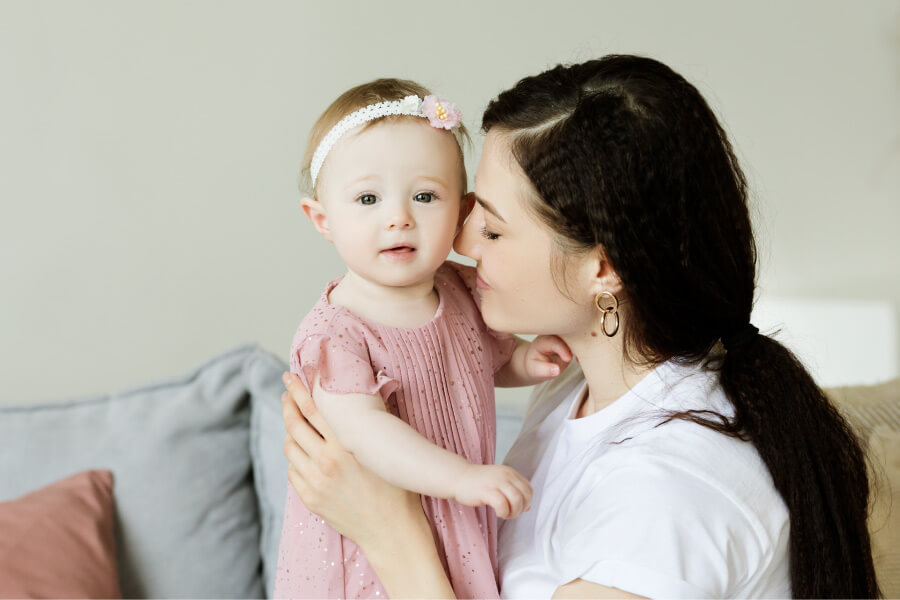 Young mother snuggles her one year old baby before her first visit to the dentist