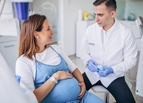 pregnant woman smiling at the dentist