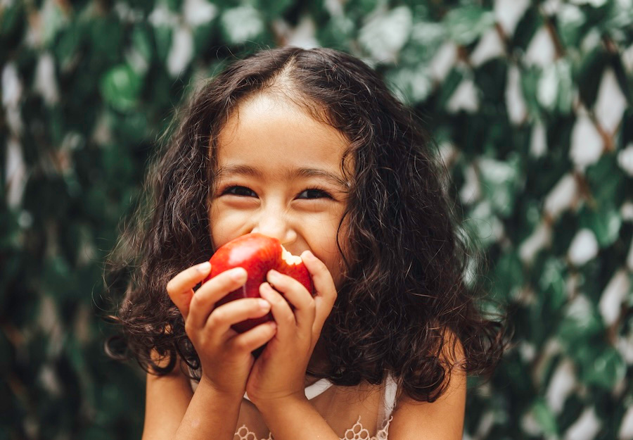 child eating an apple, an idea of healthy after school snacks